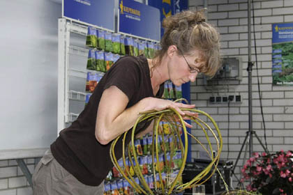 Weidenzweige mit Körpereinsatz in die Form drücken